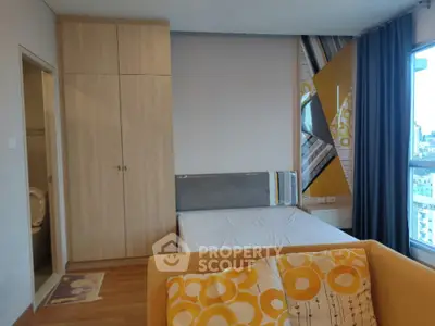Modern bedroom with city view, featuring stylish decor and ample natural light.