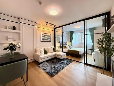 Modern open-plan living room and bedroom with stylish decor and natural light.