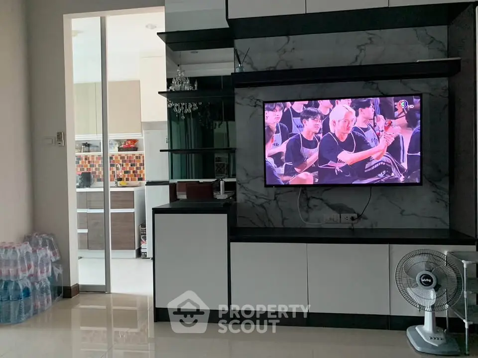 Modern living room with sleek TV unit and open kitchen view