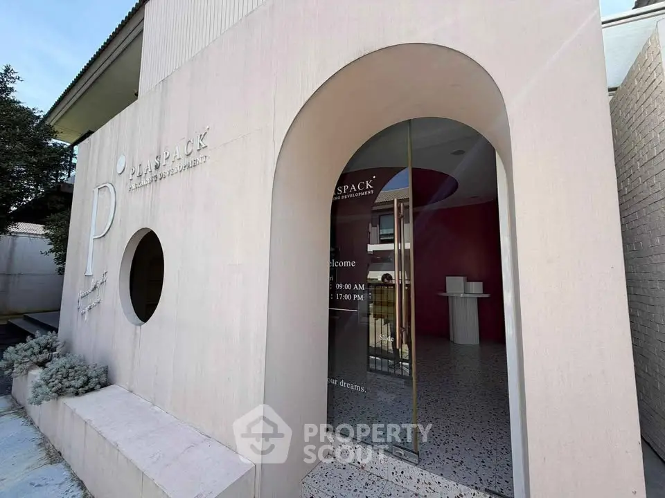 Modern commercial building entrance with unique circular window and sleek design