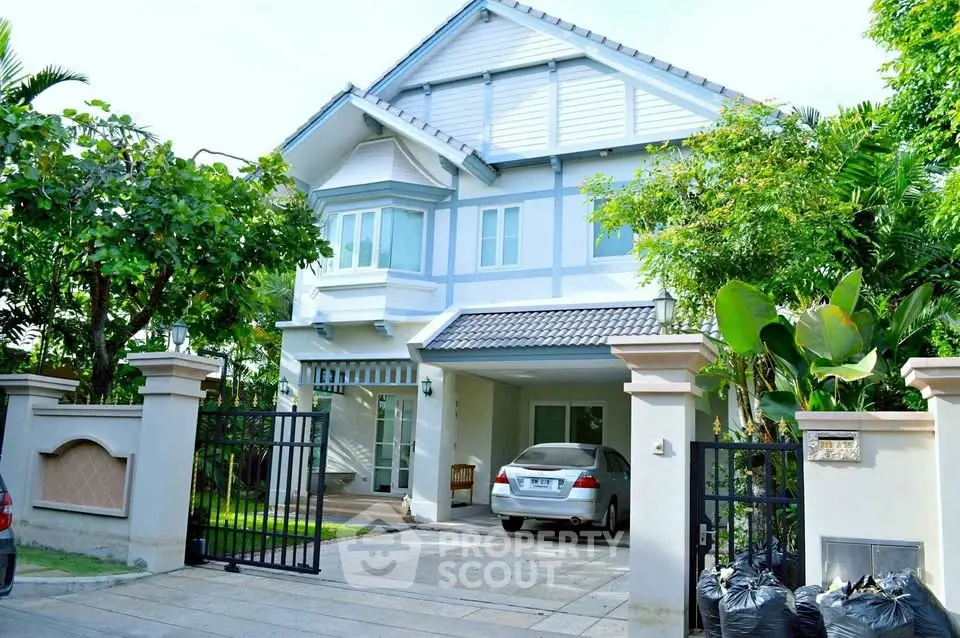 Charming two-story house with lush garden and spacious driveway in a serene neighborhood.