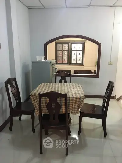 Cozy dining area with classic wooden chairs and table in a well-lit room.