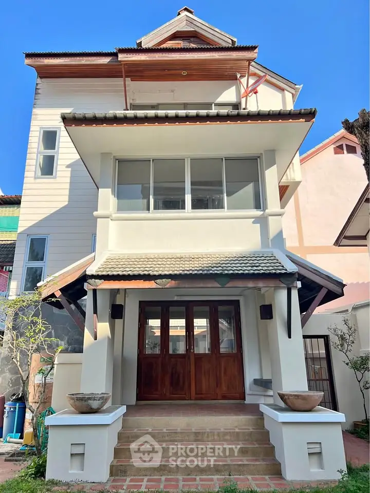 Charming multi-story house with traditional architecture and inviting entrance in a serene neighborhood.