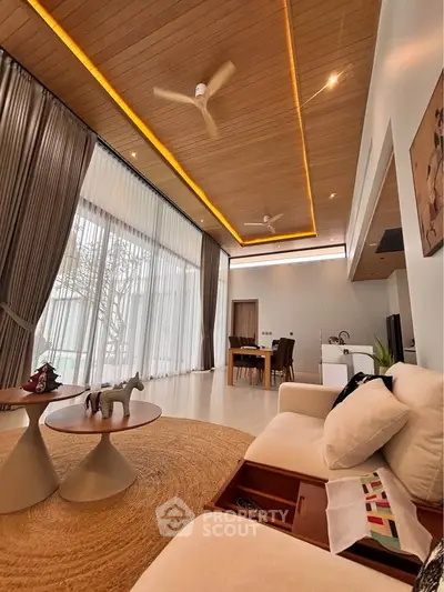 Luxurious living room with high ceilings, modern decor, and large windows offering natural light.