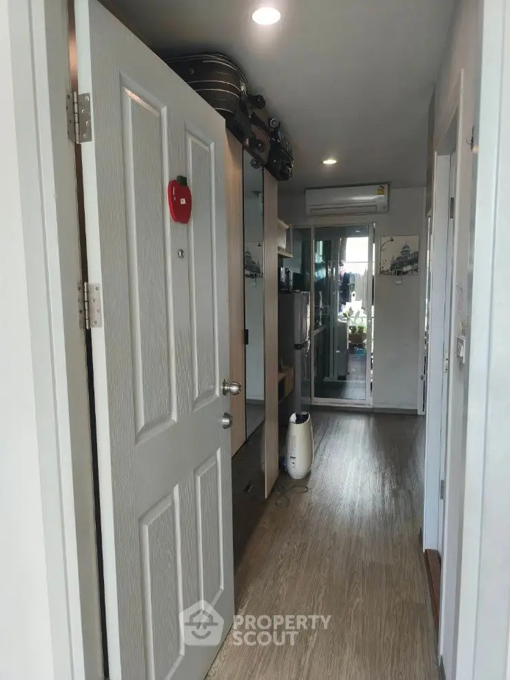 Modern apartment hallway with wooden flooring and mirrored closet doors
