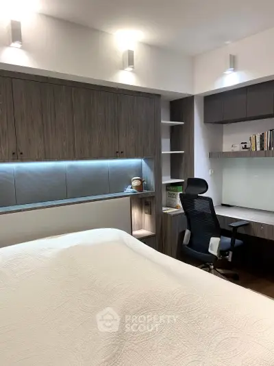 Modern bedroom with built-in storage and study area, featuring sleek design and ambient lighting.