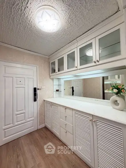 Charming entryway with elegant cabinetry and decorative ceiling light, perfect for stylish home organization.