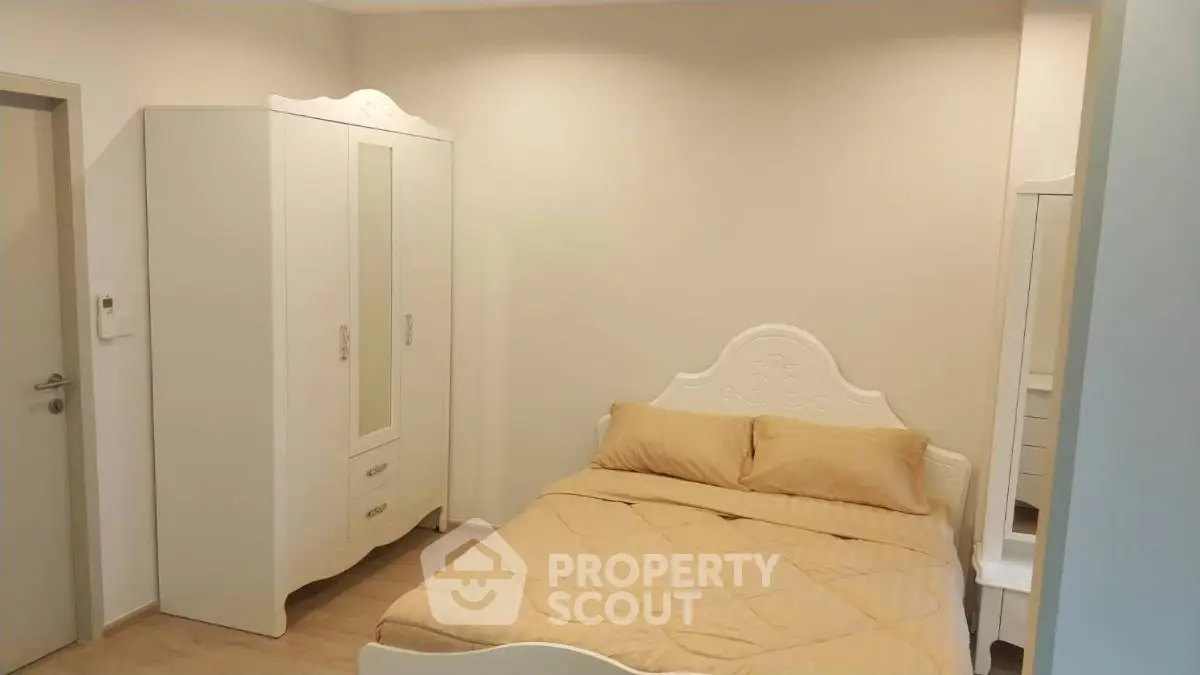 Cozy bedroom with elegant white furniture and warm lighting, perfect for relaxation.