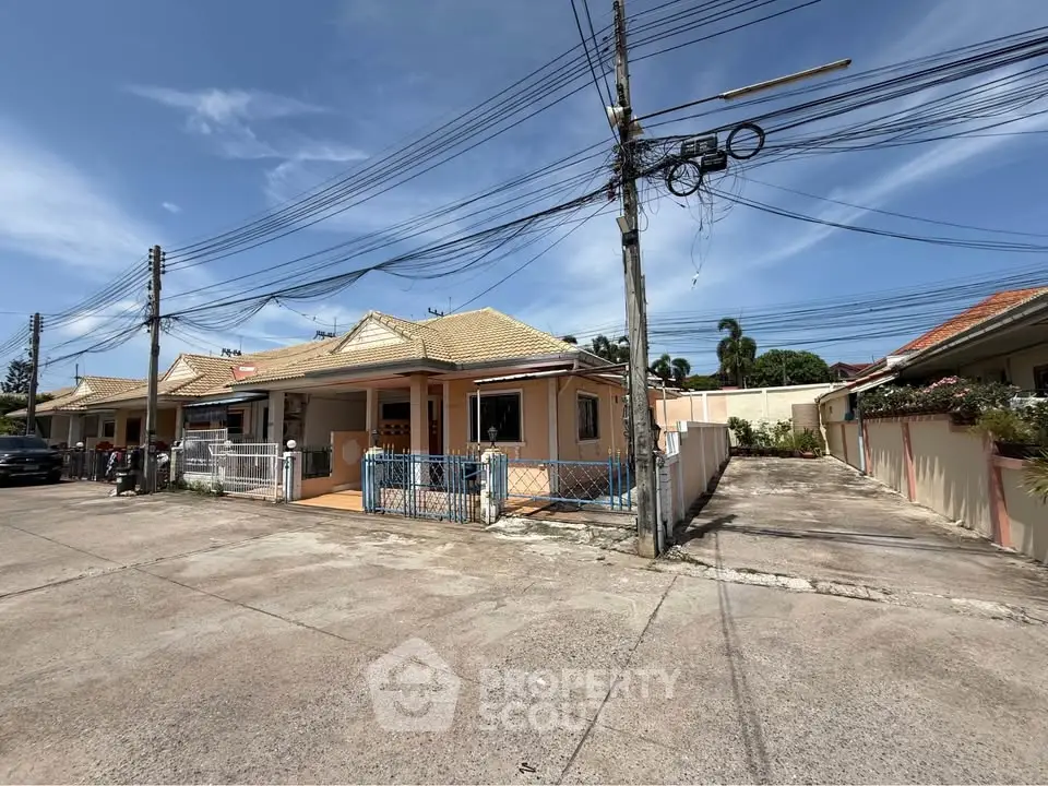 Charming single-story house with tiled roof and fenced yard in a quiet neighborhood.