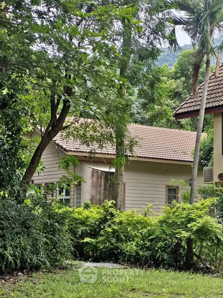 Charming house surrounded by lush greenery and trees, offering serene natural views.