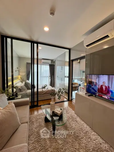 Modern living room with glass partition and cozy bedroom view