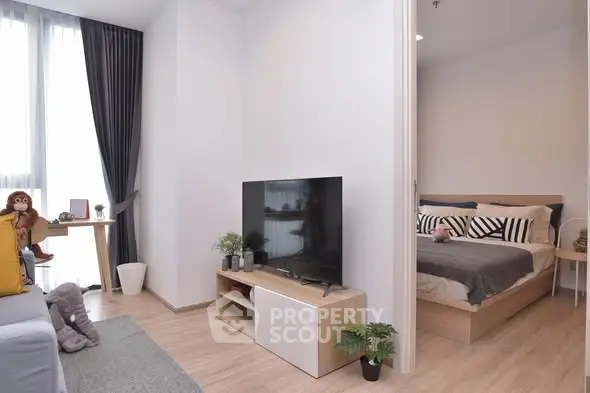 Modern living room with TV and cozy bedroom in open layout apartment