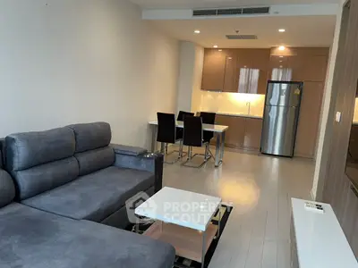 Modern open-plan living room with sleek kitchen and cozy seating area