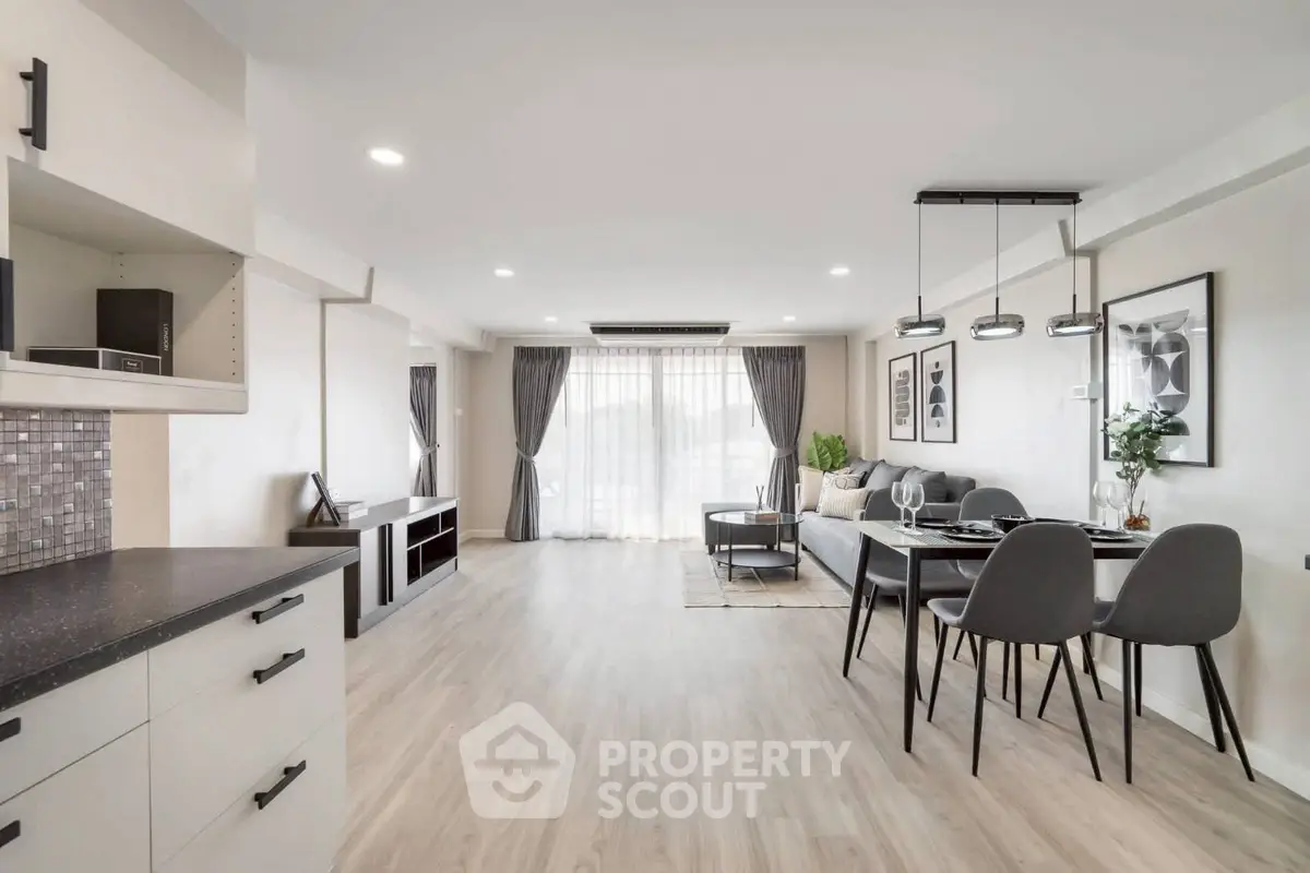 Spacious modern living room with open layout and elegant dining area, perfect for entertaining.