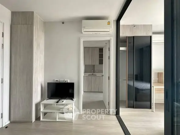Modern apartment interior with open layout, featuring a cozy living area and sleek kitchen design.
