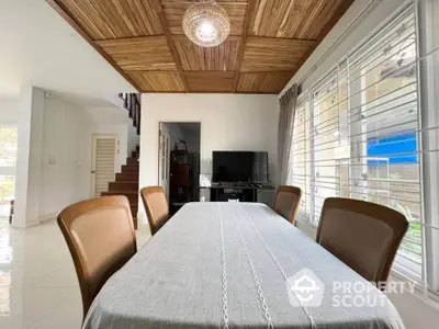 Elegant dining area with wooden ceiling and natural light