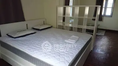 Spacious bedroom with a large bed and modern divider for added privacy.