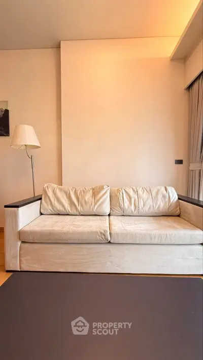 Modern living room with stylish beige sofa and floor lamp, perfect for cozy relaxation.
