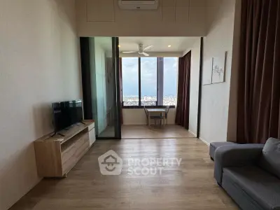 Modern living room with wooden flooring, large window view, and cozy furniture.