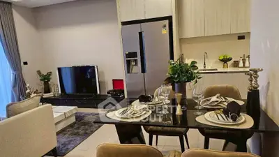 Modern open-plan living room and kitchen with sleek decor and dining setup.