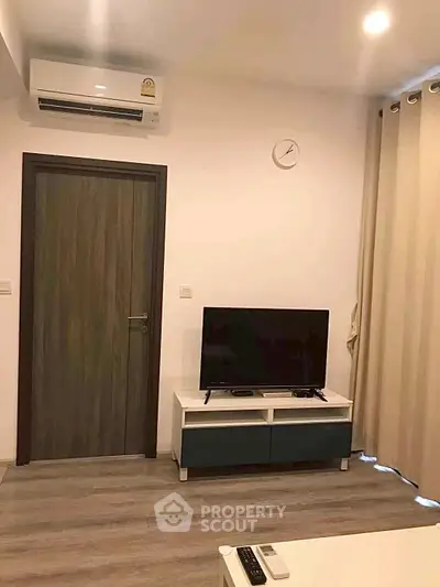 Modern living room with TV, air conditioning, and stylish decor in a cozy apartment.