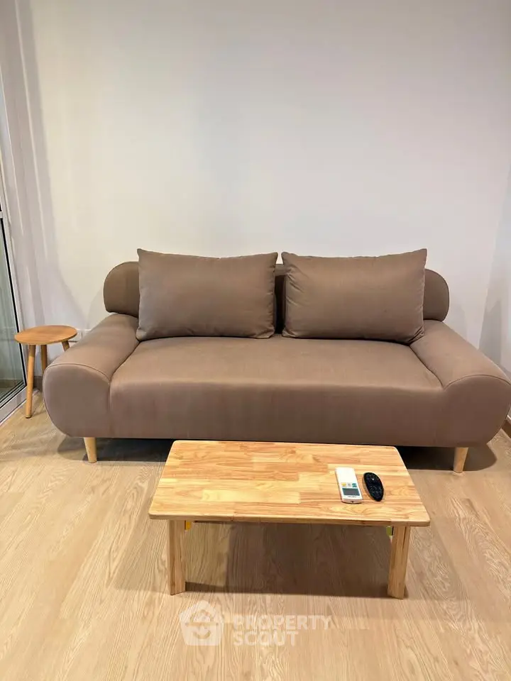 Modern living room with stylish brown sofa and wooden coffee table on elegant wooden flooring.