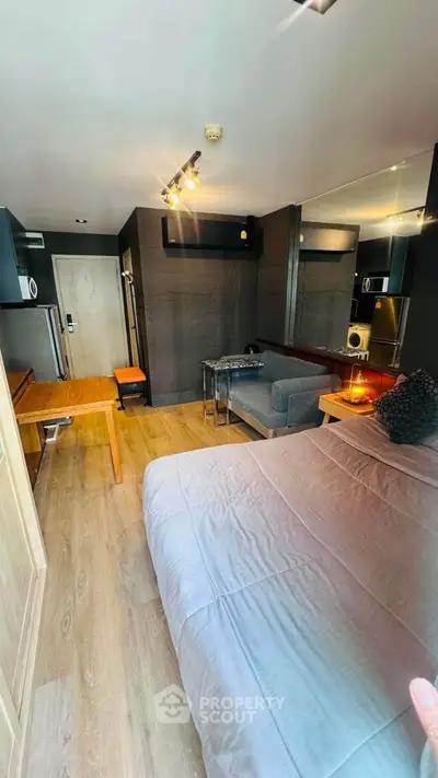Modern studio apartment with stylish decor and cozy ambiance, featuring a comfortable bed and sleek furniture.