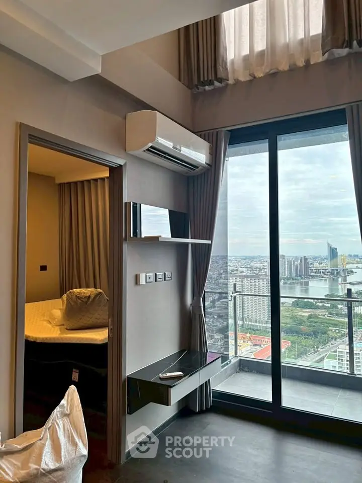 Modern high-rise apartment with stunning city view and balcony access.