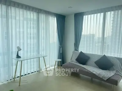 Modern living room with large windows and stylish furniture in a high-rise apartment.