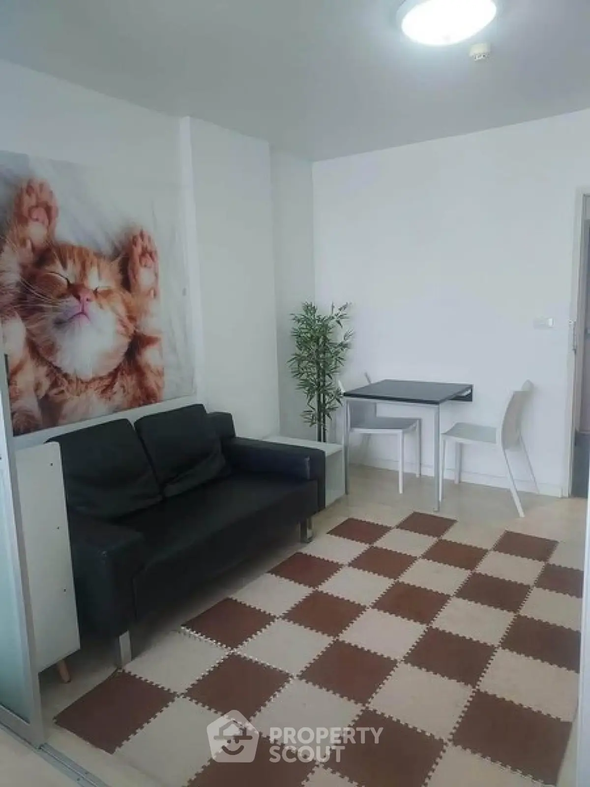 Cozy living room with modern decor and playful cat artwork, perfect for relaxation.