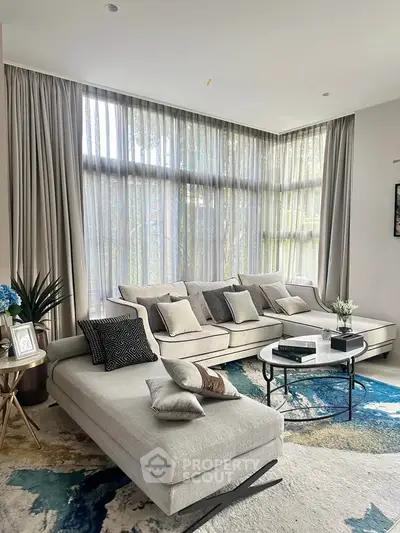 Luxurious living room with elegant corner sofa and large windows offering natural light.
