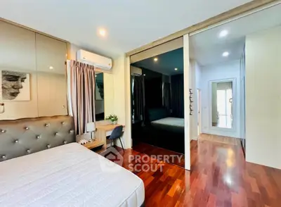Spacious modern bedroom with elegant decor and hardwood flooring