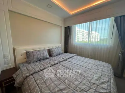 Luxurious bedroom with elegant decor and large window offering natural light.