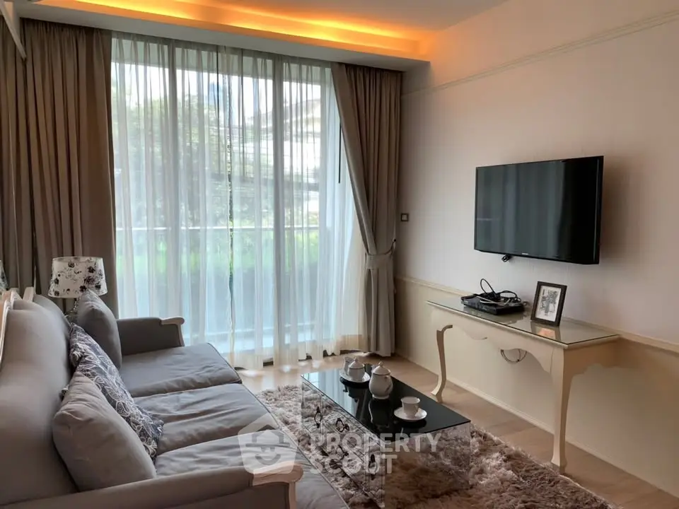 Elegant living room with large window, cozy sofa, and mounted TV, perfect for relaxation and entertainment.