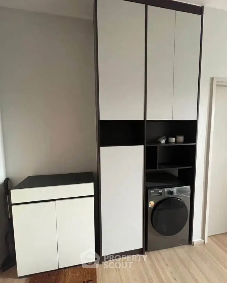 Modern laundry area with sleek cabinetry and washing machine in a stylish home interior.