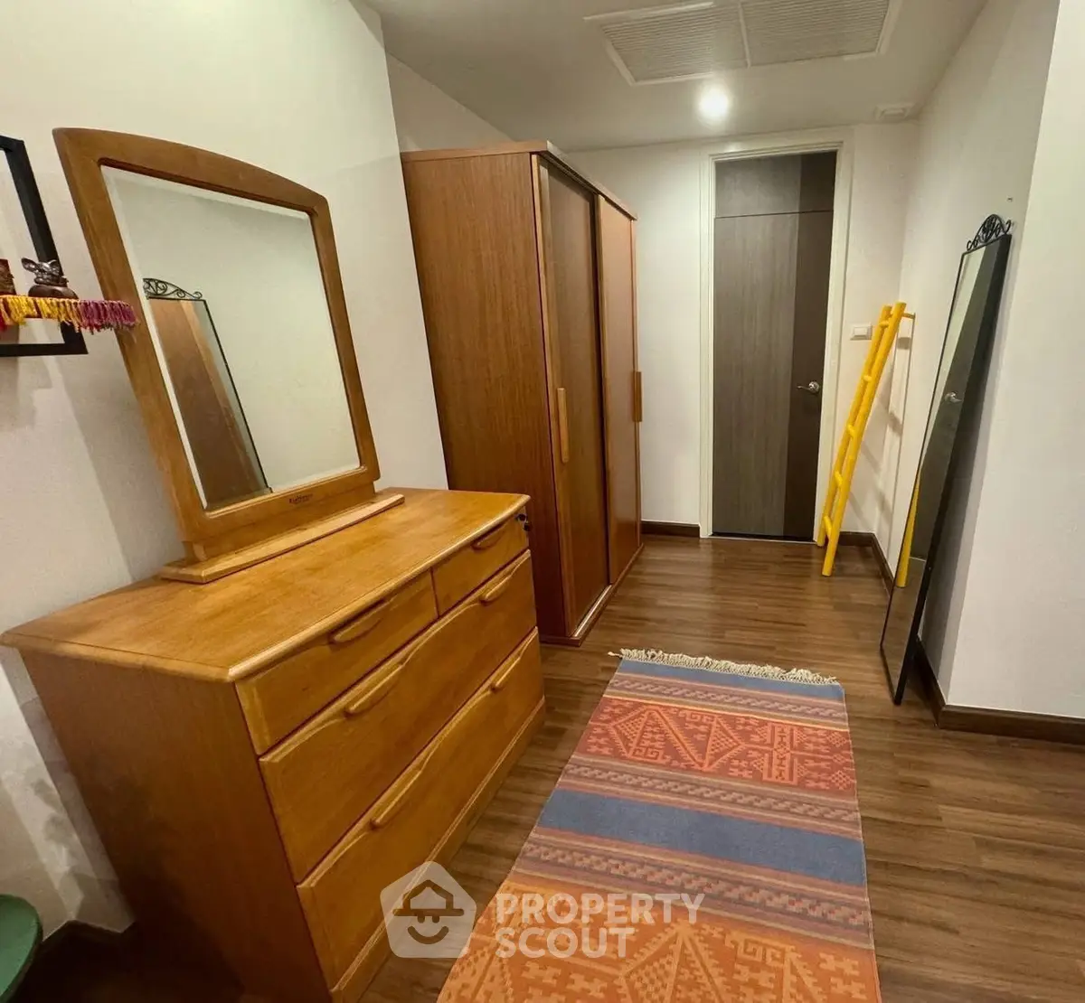 Cozy bedroom with wooden furniture and colorful rug