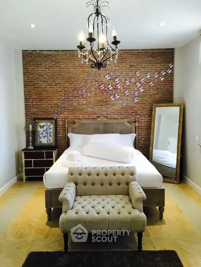 Charming bedroom with brick accent wall and elegant chandelier