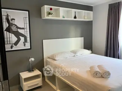 Modern bedroom with stylish decor and cozy ambiance, featuring a neatly made bed and elegant shelving.