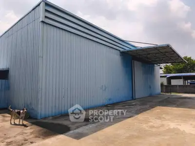 Spacious industrial warehouse with large exterior and ample parking space.