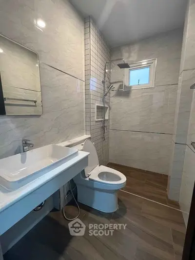 Modern bathroom with sleek fixtures and elegant tile design, featuring a spacious shower area.