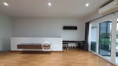 Spacious modern living room with wooden flooring and large windows