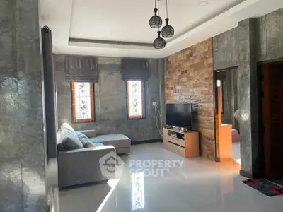 Modern living room with stylish decor, large windows, and cozy seating area.