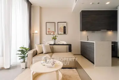 Modern living room with open kitchen, stylish decor, and natural light