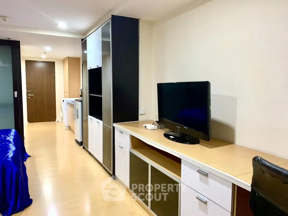 Modern apartment interior with sleek furniture and built-in storage solutions.