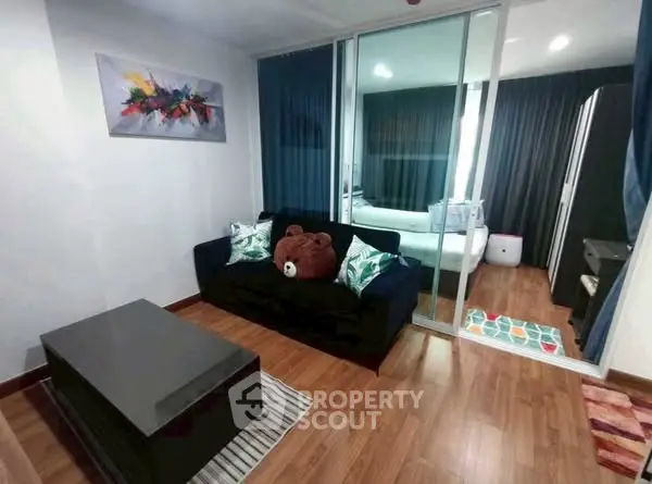 Modern living room with cozy sofa and stylish decor in a compact apartment setting.