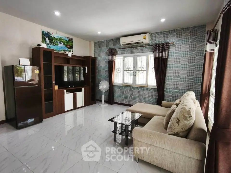 Spacious living room with modern decor and ample natural light, featuring a comfortable sofa and entertainment center.