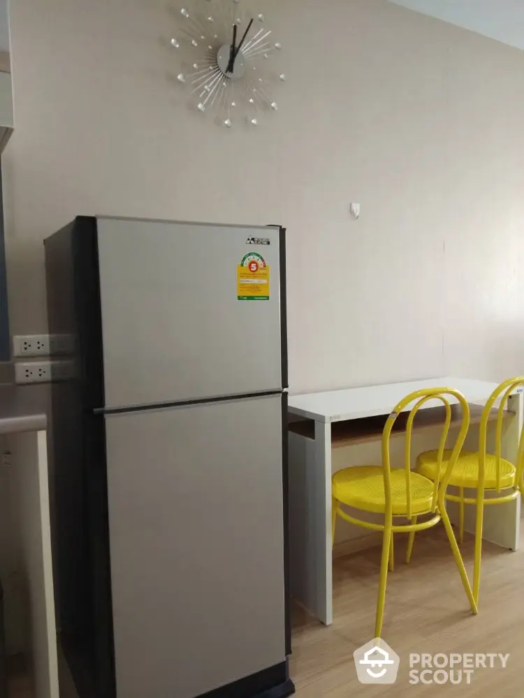 Modern kitchen with sleek fridge and stylish yellow chairs