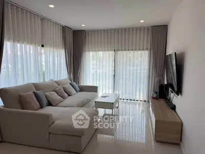 Spacious modern living room with large windows and cozy sectional sofa.