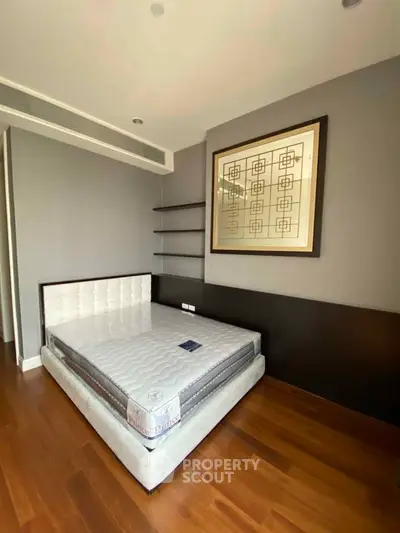 Modern bedroom with stylish decor and hardwood flooring in a luxury apartment.