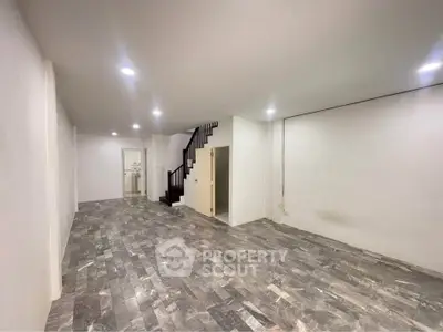 Spacious interior with modern flooring and staircase, ideal for versatile living or office space.